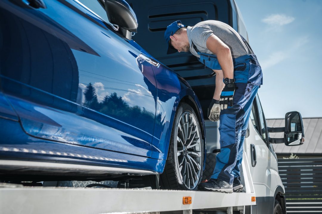 car-repossession-worker-securing-vehicle-on-his-towing-truck.jpg